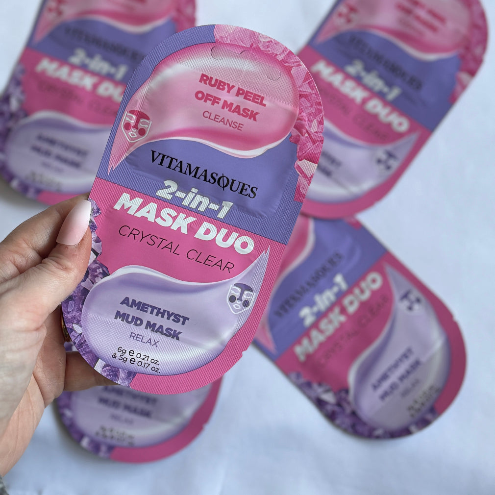 Packaging of 2-in-1 Mask Duo with one sachet labeled 'VITAMASQUES 2-in-1 MASK DUO CRYSTAL CLEAR' and another showing 'AMETHYST MUD MASK RELAX'. The background has more sachets with the same design.
