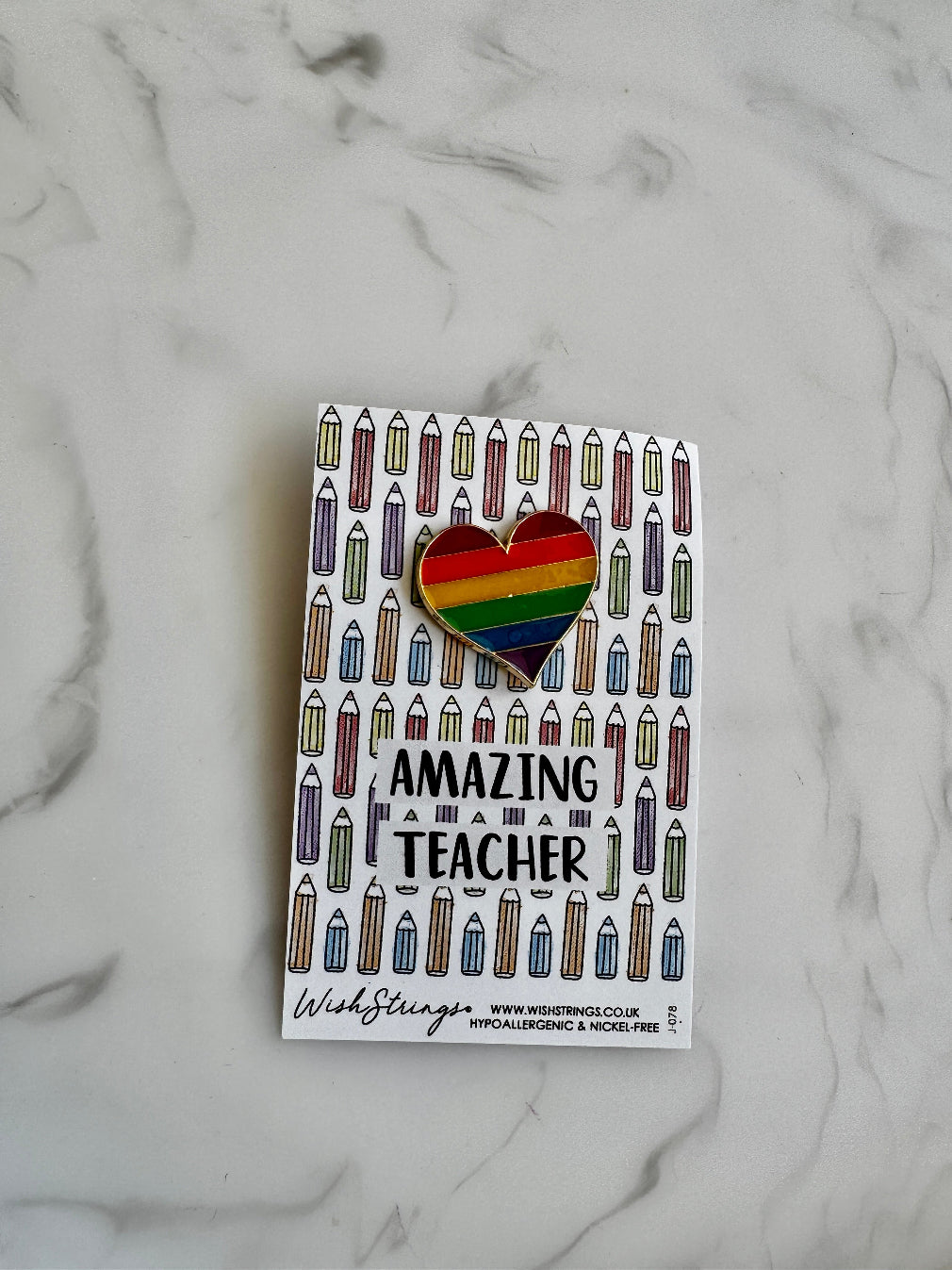 rainbow coloured heart pin on a Amazing Teacher backing card