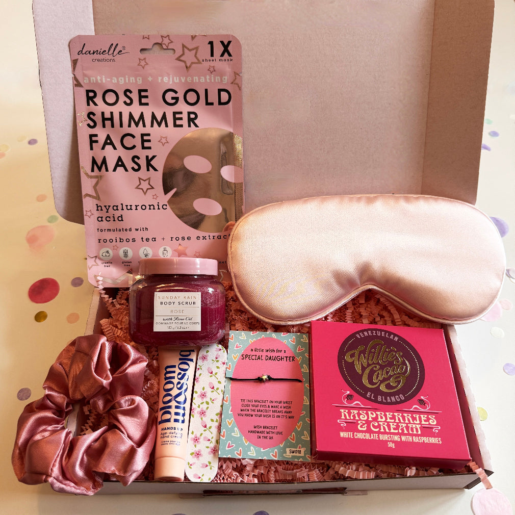 Pink pamper gift box with rose gold shimmer face mask, satin eye mask, Blossom hand cream, raspberry chocolate, rose body scrub, scrunchie and special daughter wish bracelet.