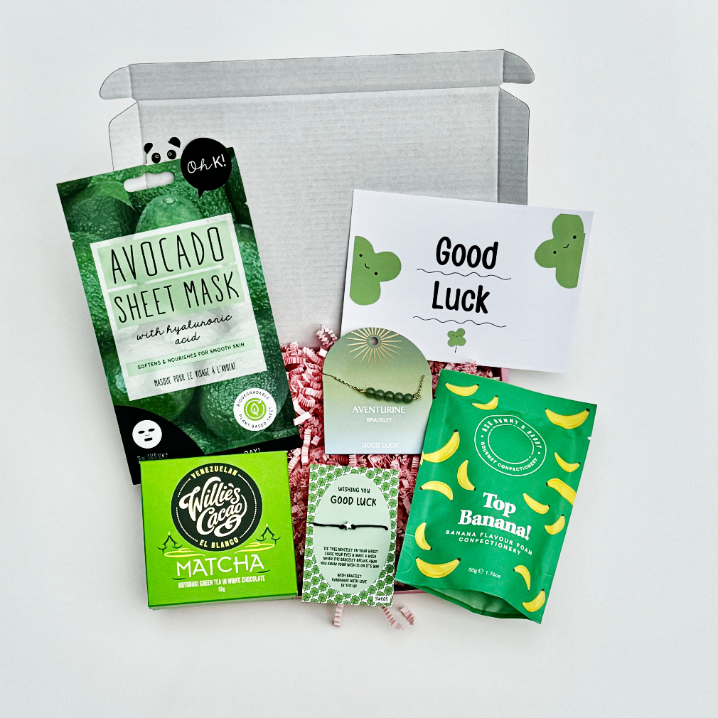 Good luck gift box with avocado face mask, matcha chocolate, wish bracelet, aventurine crystal, Top Banana sweets, and green clover card.