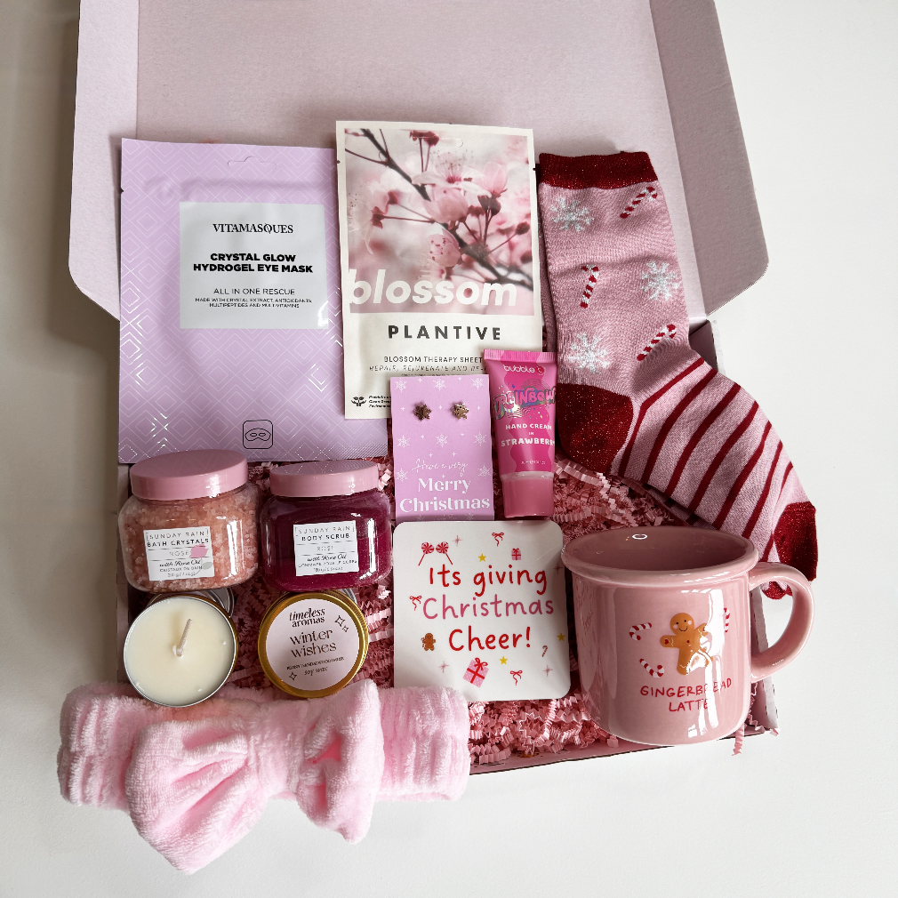 Gifting box with Christmas-themed products including a mug, candles, and bath salts.