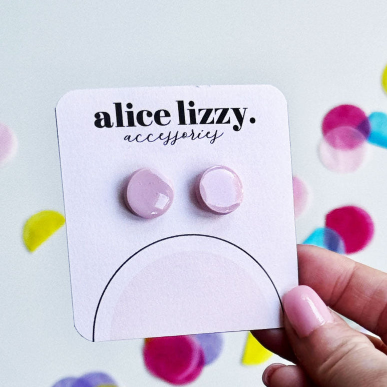 Pink earrings on a 'alice lizzy.' accessories card with colorful confetti in the background