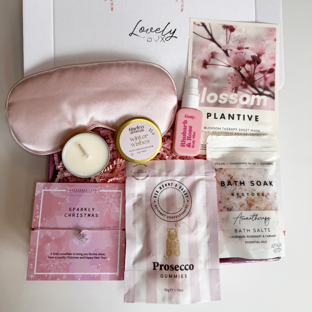 Collection of self-care products including a sleep mask, candle, and bath soaks on a white background.