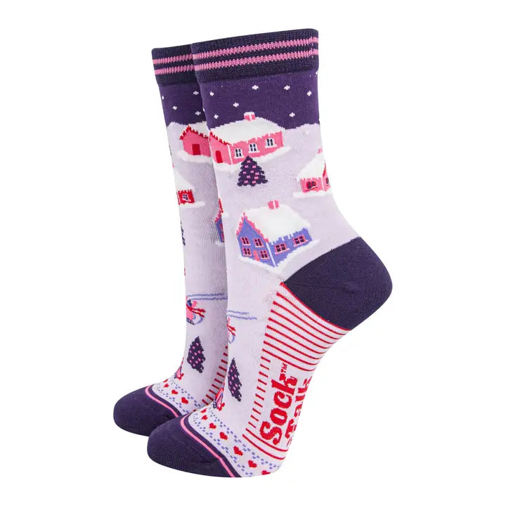 Pair of socks with a winter village design on a white background