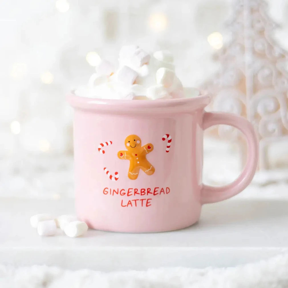 Pink mug with 'Gingerbread Latte' text and gingerbread man design, filled with hot chocolate and marshmallows.