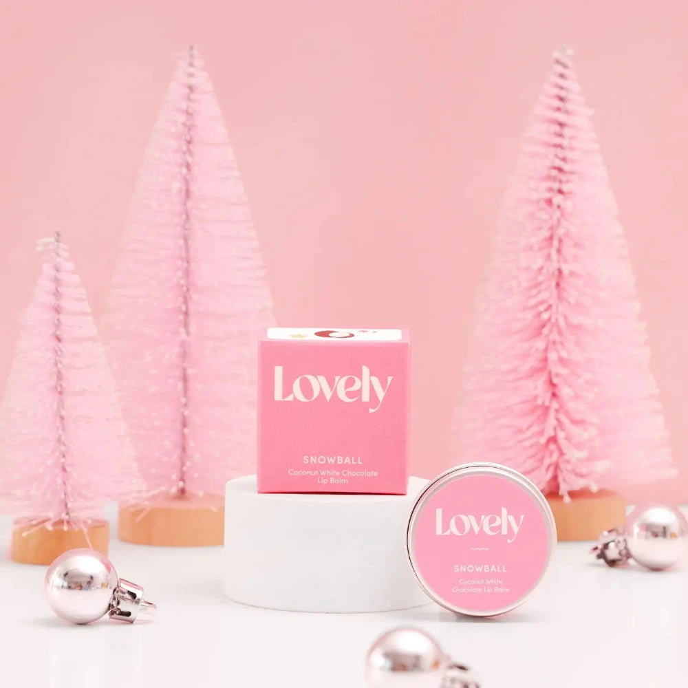 Pink 'Lovely' product with decorative trees and ornaments on a pink background