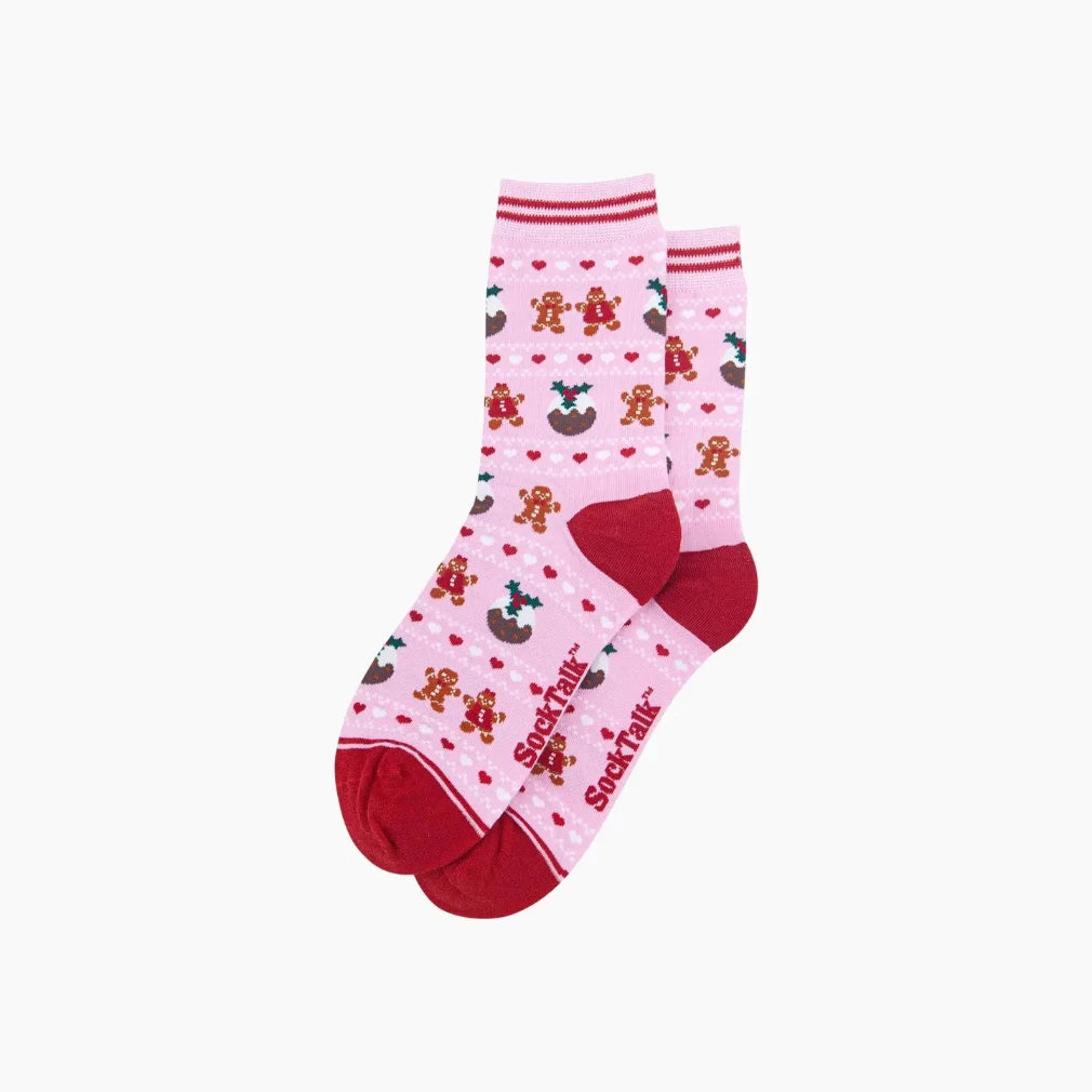 A pair of pink crew socks with a red toe and heel, decorated with a pattern of gingerbread men, cookies, and red hearts. The brand name 'Socktalk' is printed vertically in red on the side.