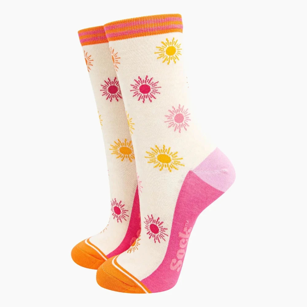 Pair of knee-high socks with sunflower designs on a white background