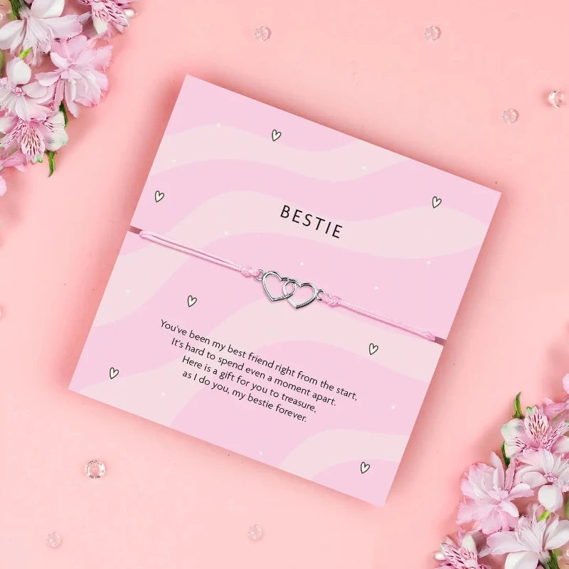  Featuring a silver-tone interlocking heart charms on a soft pink adjustable cord, this bracelet is a beautiful symbol of connection, loyalty, and love between best friends.