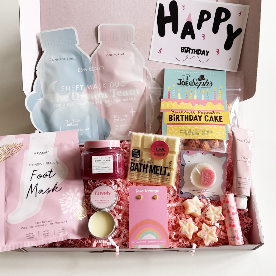 Birthday gift box with self-care items including foot mask, bath melt, and candles.