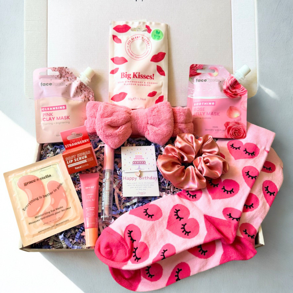 Pink birthday pamper gift box with clay face mask, rose jelly mask, eye masks, lip scrub, lip balm, lip gloss, fluffy spa headband, satin scrunchie, birthday bracelet, pink socks and sweets.