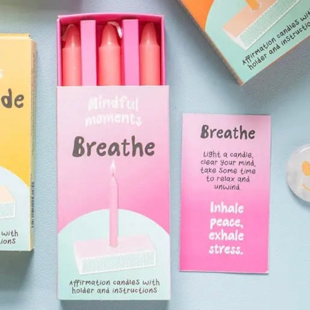 Pink candles in a box labeled 'Mindful moments Breathe' on a light blue background.