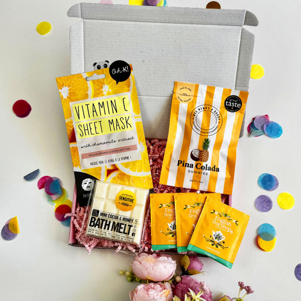 Assorted beauty products including sheet masks and bath melts on a white background with colorful confetti.