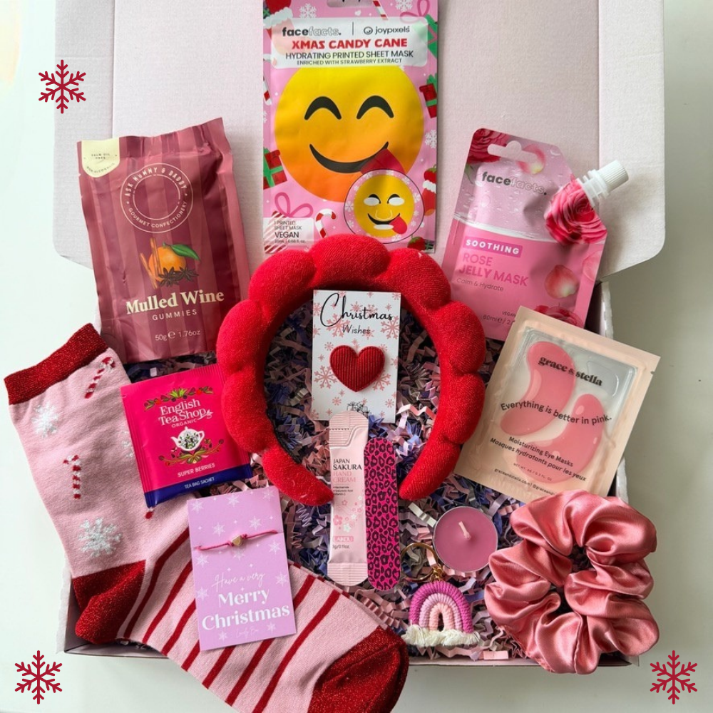 Christmas gift box for her with festive socks, red spa headband, face masks, hand cream, satin scrunchie, mulled wine gummies and pamper treats.