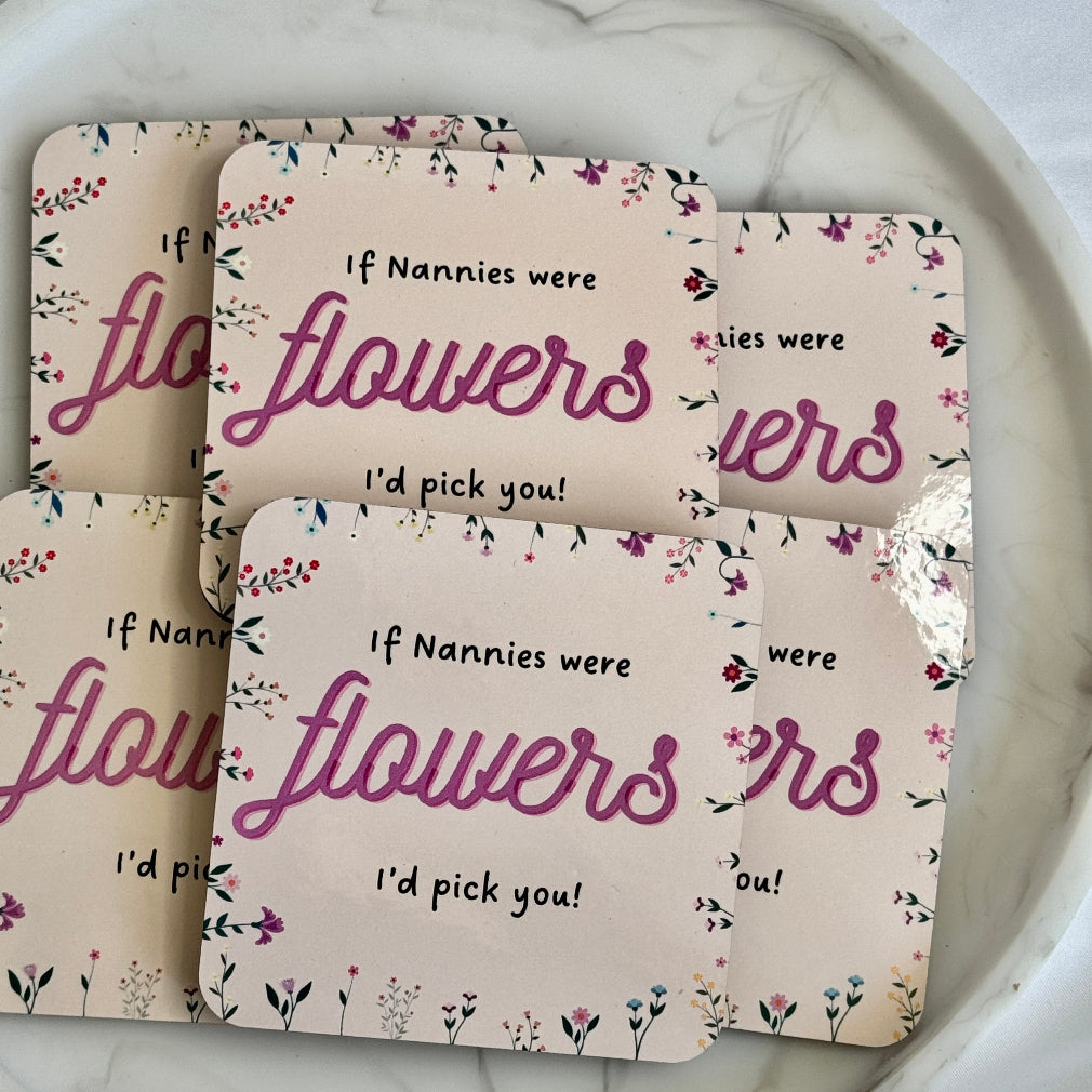 light pink coaster with purple writing and delicate flowers round the boarder - If Nannies Were Flowers, I'd Pick You written on it