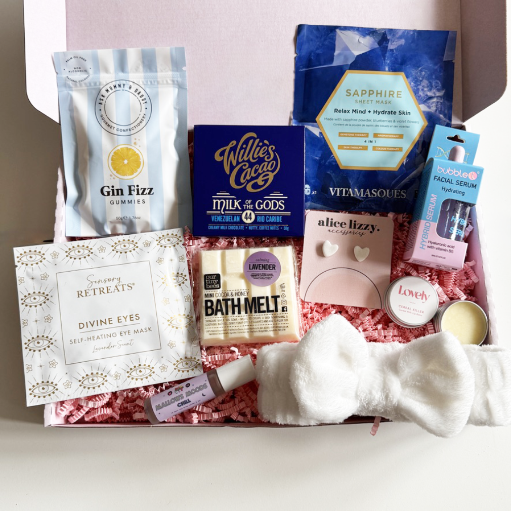 Assorted self-care products including gummies, bath melt, and eye mask in a box.