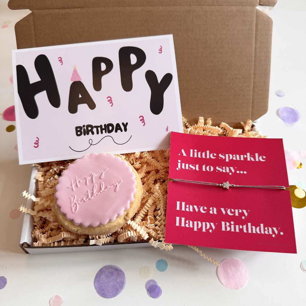 Gift box with a cookie, card, and bracelet on a white background