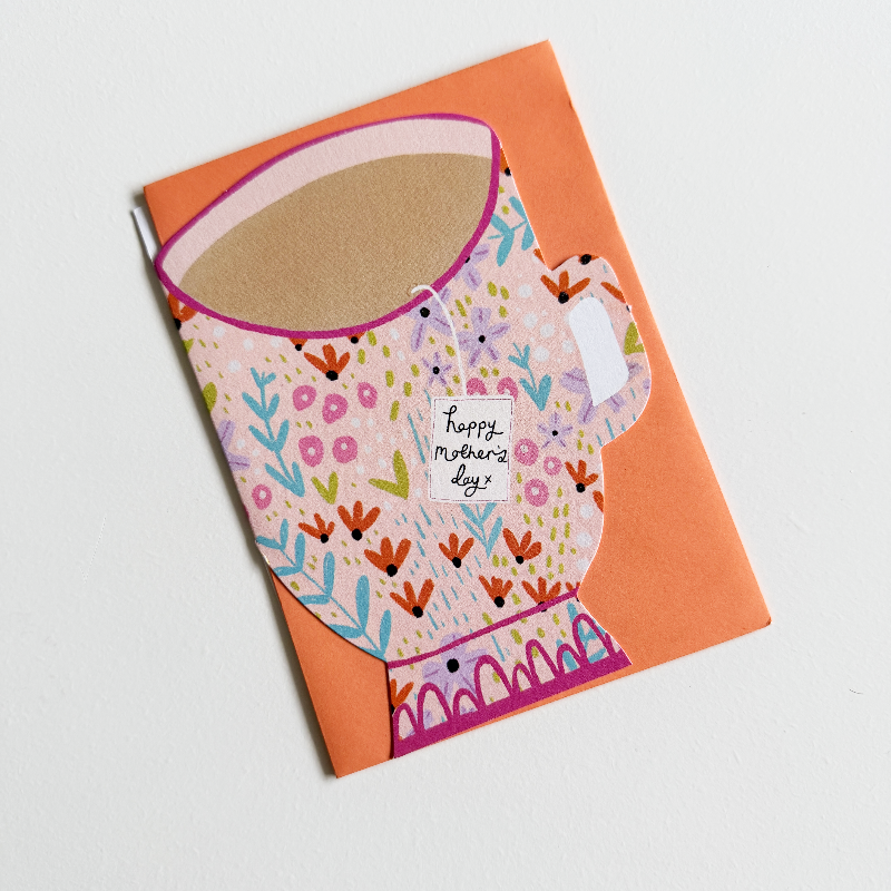 Card with a colorful tea cup design and 'Happy Mother's Day' message on an orange envelope.