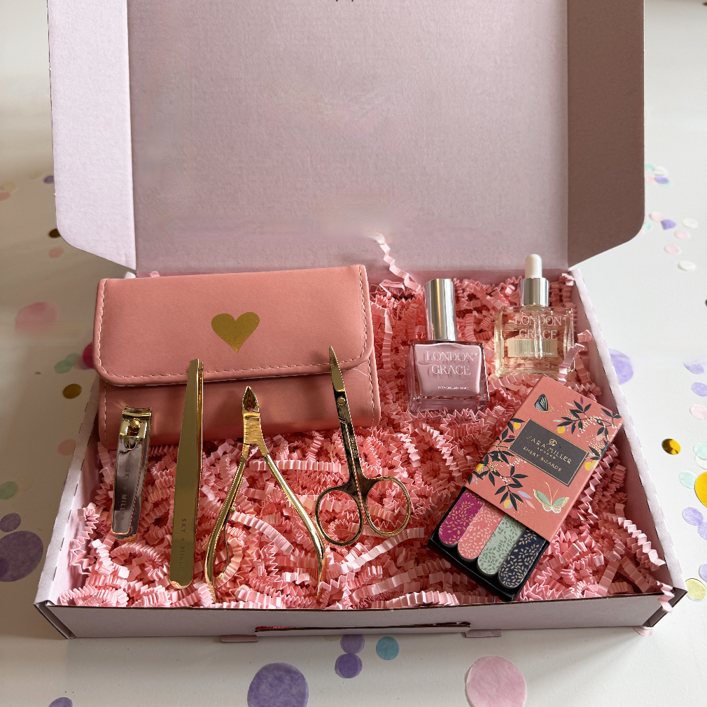 Gift set with nail care tools, nail polish, and a small bag in a box.