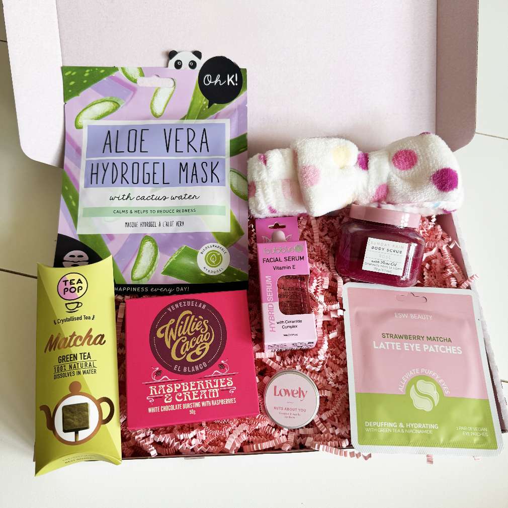 Assorted beauty products including aloe vera hydrogel mask, matcha green tea, and raspberry cream product on a white background.