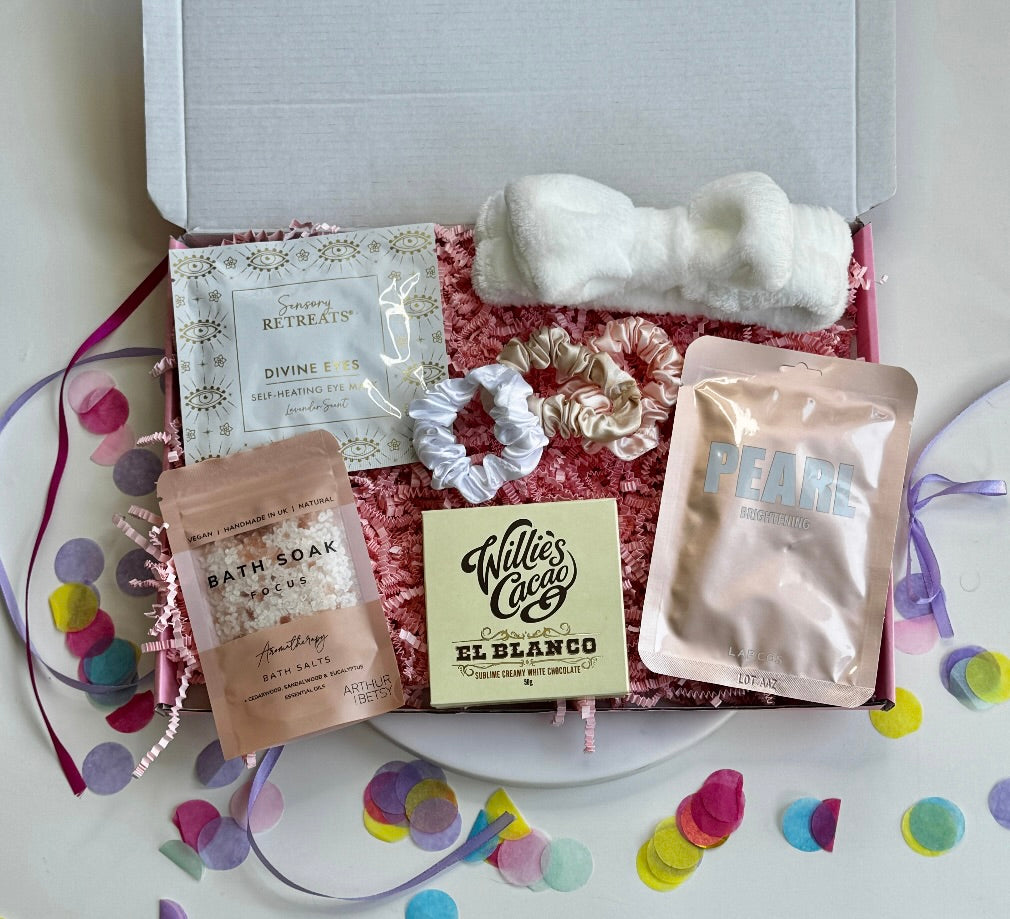 Relaxation gift box with self-heating eye mask, bath salts, PEARL face mask, El Blanco white chocolate, fluffy headband, and satin scrunchies.