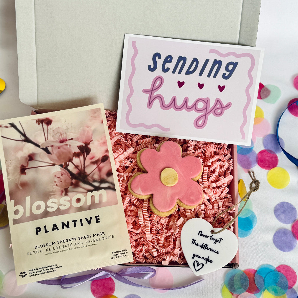 a treatbox with skincare, keepsake and biscuit and a sending hugs card