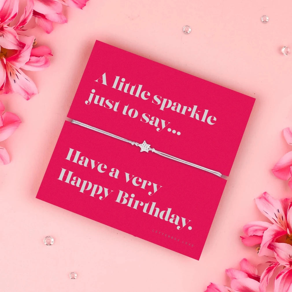 Pink birthday card with a silver bracelet and pink flowers on a pink background