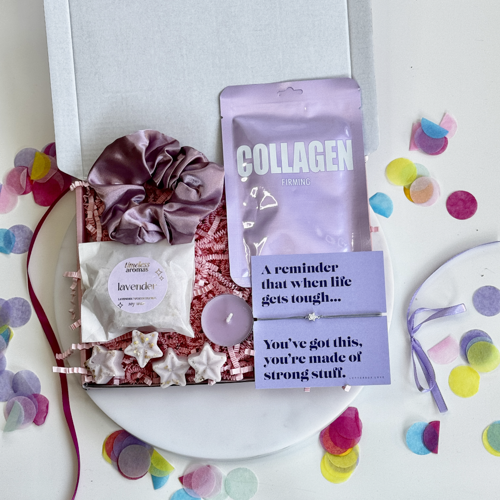 Encouragement gift box with collagen sheet mask, lavender wax melt, lilac scrunchie, star-shaped melts, lilac tealight, and "You've Got This" bracelet and card.