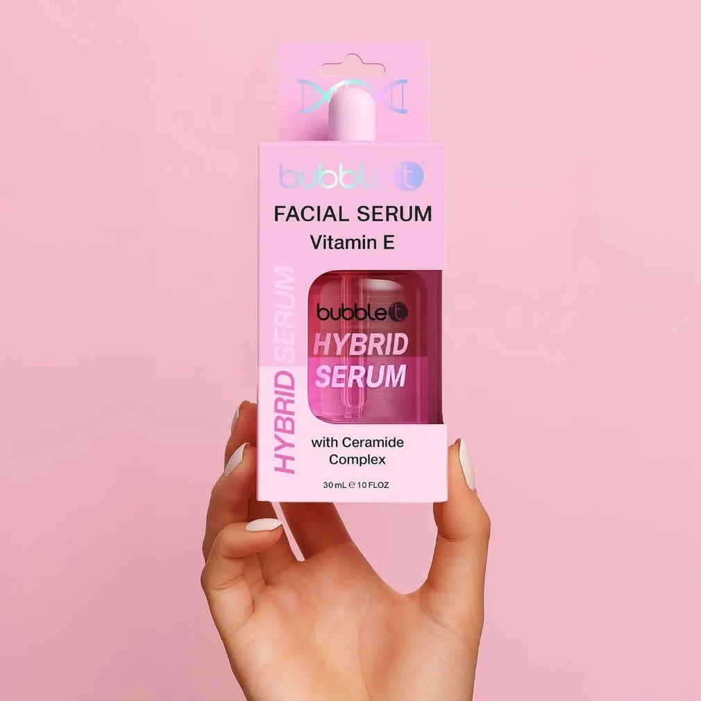Hand holding a package of bubble T Hybrid Serum against a pink background