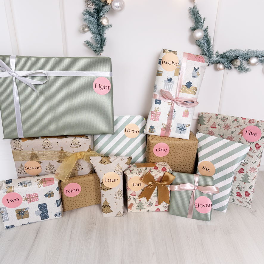 Collection of gift boxes with decorative paper and ribbons on a light wooden surface.