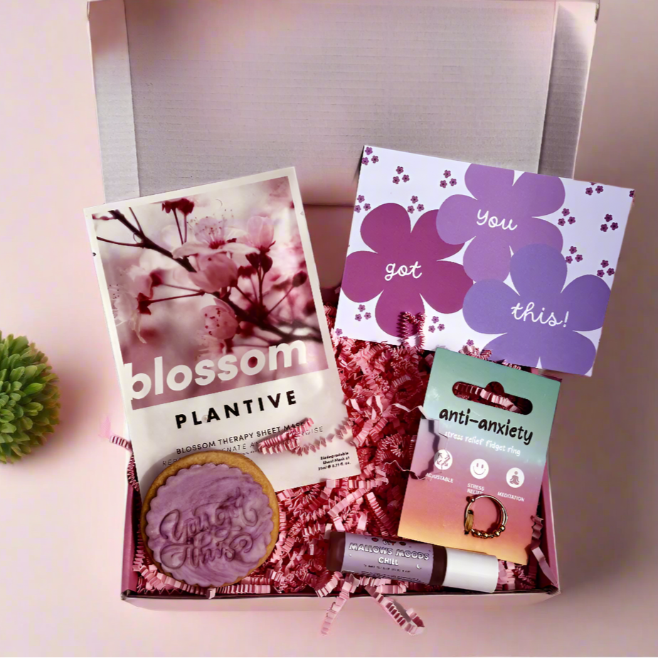 Encouragement gift box with “you got this” biscuit, anti-anxiety ring, blossom face mask, and chill roller balm – ideal for stress relief and self-care.
