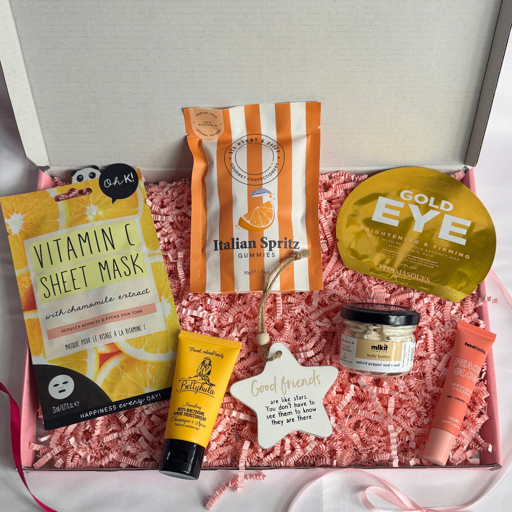 treatbox including skincare, edible treats and keepsakes with a themed note card gold themed