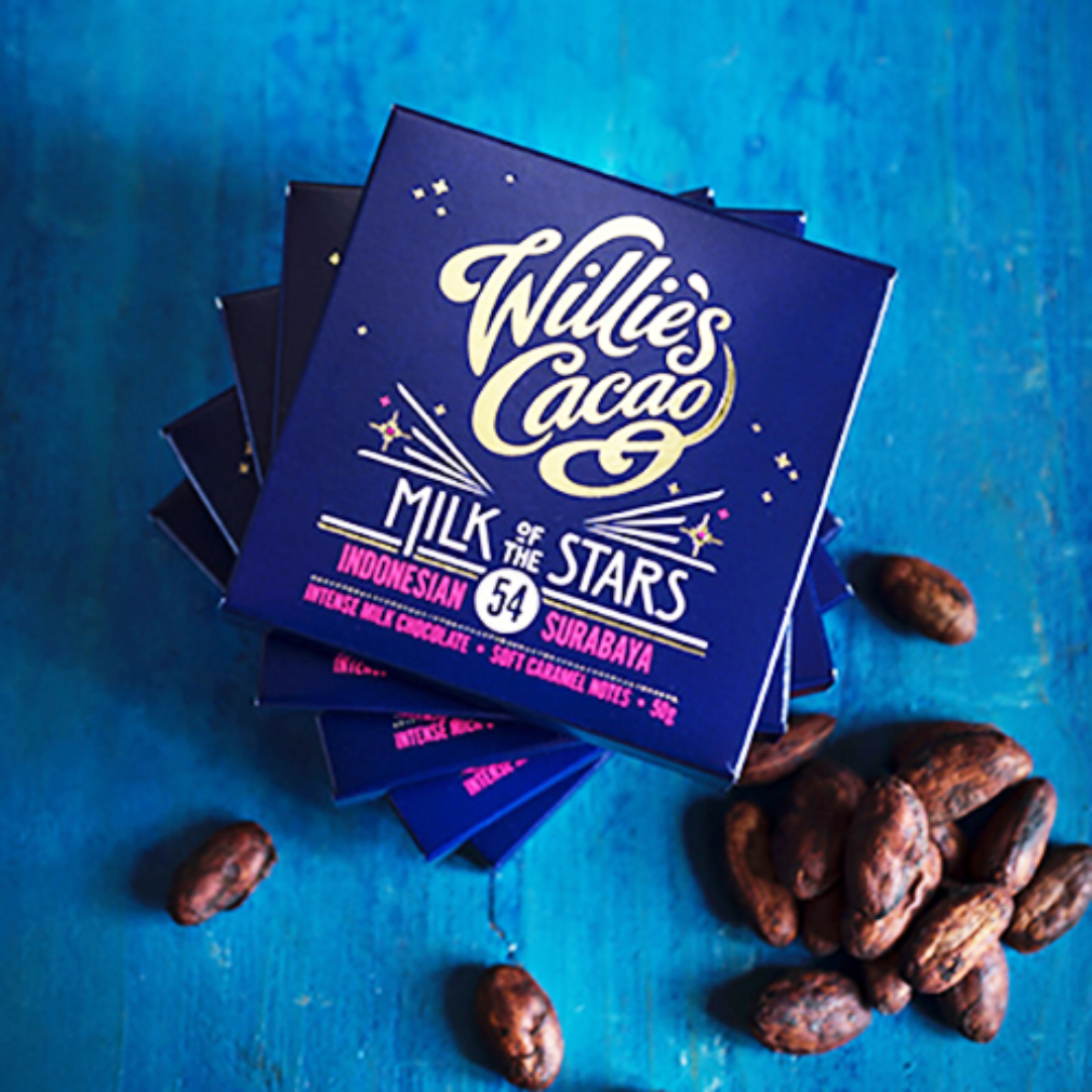 Willie's Cacao chocolate bars on a blue background with cacao beans.